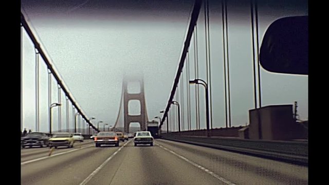 Vintage point of view of car crossing Golden Gate Bridge from Presidio Pacific point to the north. In the traffic to and from the city.