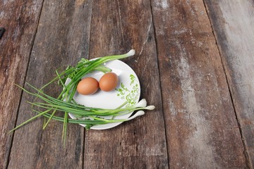 fresh chicken egg on a plate  and onion in wooden table