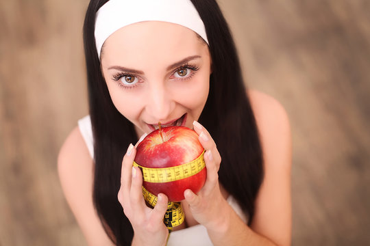 Young pretty smiling woman standing holding red apple.Concept for healthy food