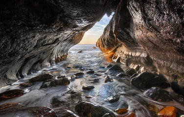 Inside the cave looking to the ocean, sunset on a isolated cave on a beach - 131802553
