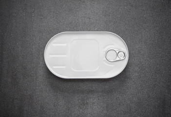 closed canned in a white oval box on a gray background, view from above