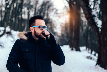 Man with beard vape electronic cigarette outdoor