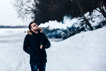 Man with beard vape electronic cigarette outdoor