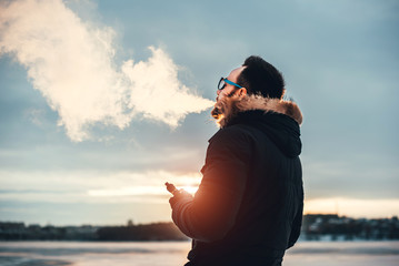 Man with beard vape electronic cigarette outdoor