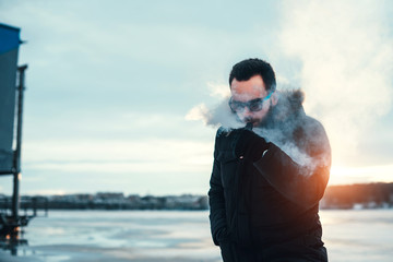 Man with beard vape electronic cigarette outdoor