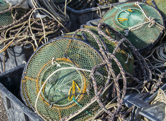  Green fishing creels and net stacked on the fishing port.