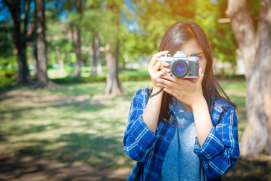 Portrait of happy Asian woman taking photos with a DSLR camera