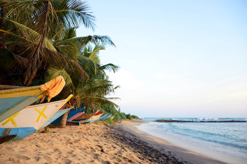 Obraz na płótnie Canvas Boats on a tropical beach at sunset, Mirissa, Sri Lanka