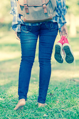 Barefoot woman walking on the grass