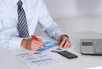 Businessman sitting on desk and writing a paper