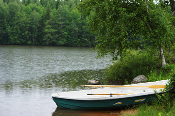 Naklejka na ściany i meble boat on a coast on a forest lake