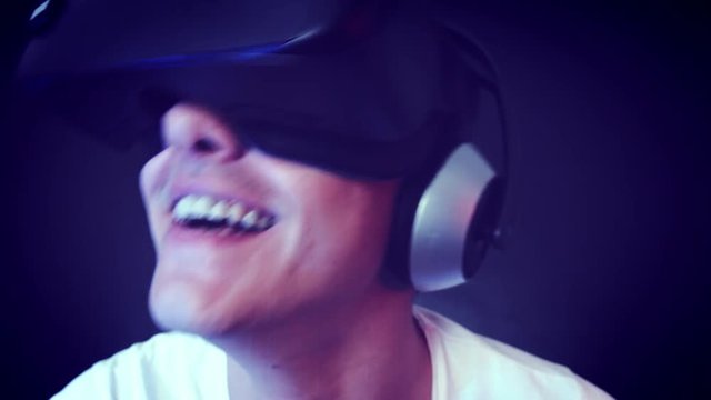 Laughing young man wearing VR Headset experiencing virtual reality. Captured with Blackmagic Production Camera 4K with RAW settings.