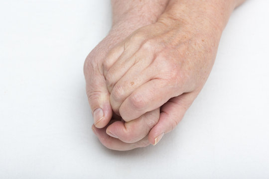 Elderly couple is holding each others hand. Wrinkled hands. Love and care.
