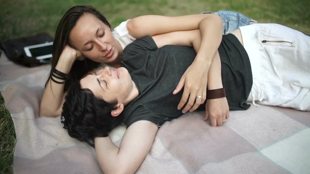 Sweet lesbians hugs and relaxing on cover in park