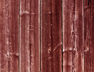 Weathered red wooden fence texture with nails.