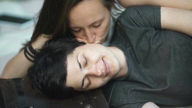 Close-up: two girls kissing on a cover in the park