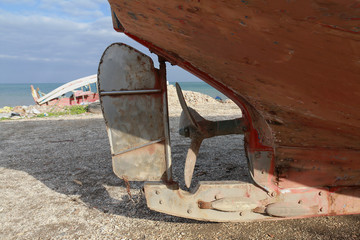 Detail of the propeller of an old boat stranded on the beach
