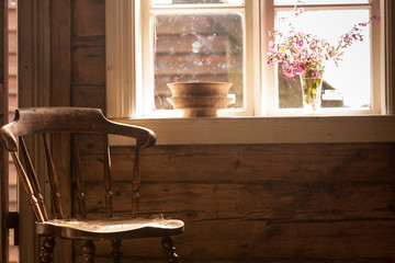 Vintage wooden chair, old cottage next to window