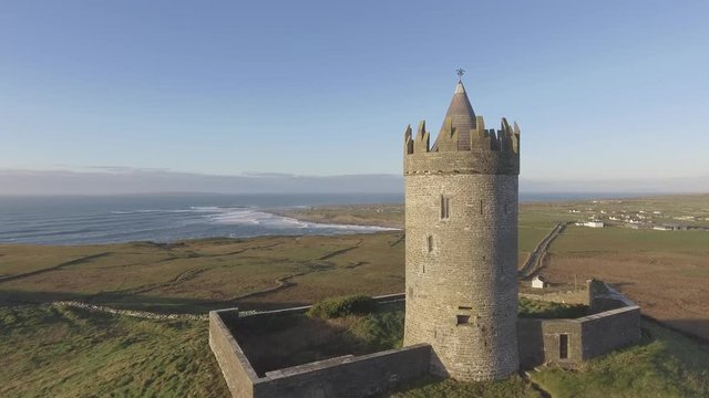 Epic Aerial Scenic Irish Castle landscape view from Doolin in County Clare. Famous tourist attraction along the wild atlantic way Ireland. Aran islands coastal beach in the distance. Flat profile 