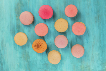 Various macarons on vibrant blue texture with copyspace