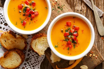 Wall murals meal dishes Homemade pumpkin soup in a white ceramic bowl on a wooden rustic table, nutritious and delicious vegetarian dish