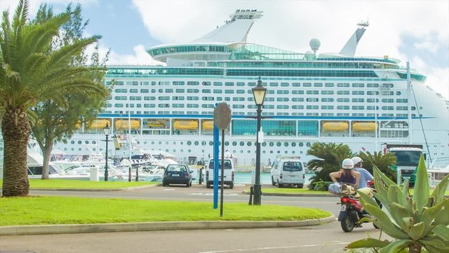 Bermuda Cruise Passengers Exploring the Island on a Rental Scooter, Riding in the Royal Naval Dockyard Area with a Large Cruise Ship Docked at King's Wharf
