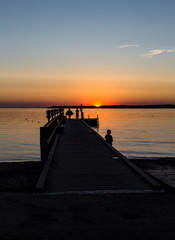 Jetty with kids at sunset.