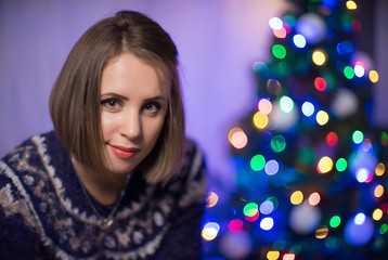 A portrait of girl with christmas tree on the background.