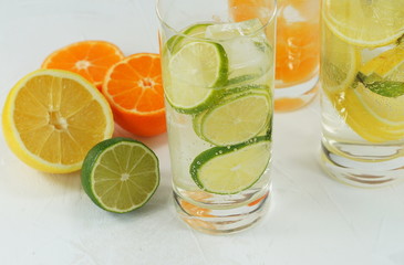 detox mineral water with lime, tangerine and lemon on a light background