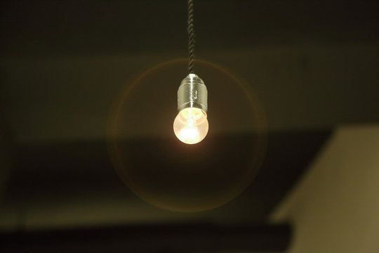 A simple light bulb lit on a black wire