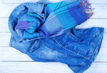 ladies fashion denim vest and a blue scarf on a white wooden background