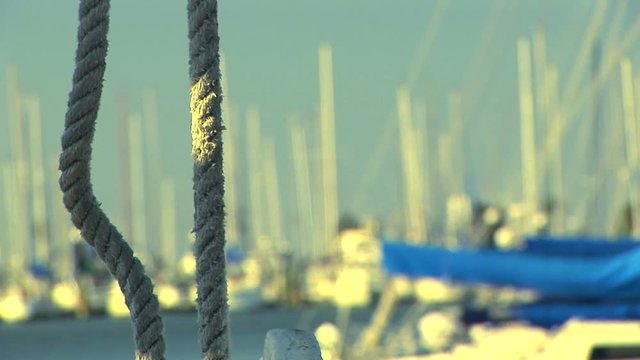 closeup view of rope hanging from the trawling boat. Out of focus sailboats in the background