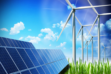 Renewable energy concept with solar panels and wind turbines on green field