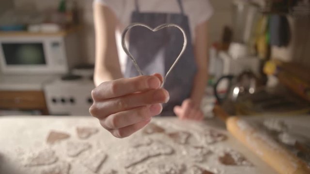 girl cooks biscuits for Valentines Day