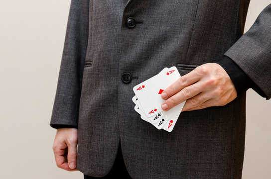 Businessman holding a poker of aces card in his hands