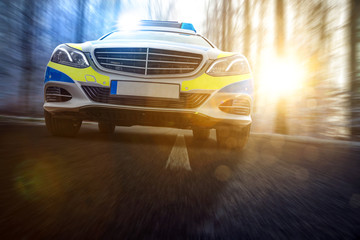 Polizeiauto auf Landstraße mit Blaulicht