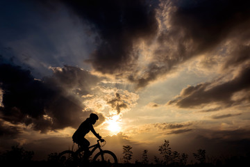 Obraz premium silhouette of bicycle rider at sunset
