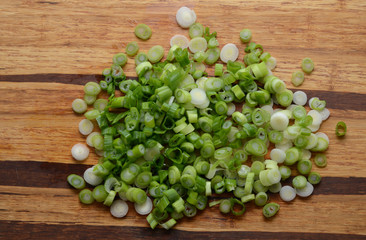 Sliced, chopped spring onions, salad onions, green onions or scallions on wood background