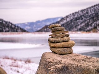 Isolated Rock Cairn with Frozen Lake Background