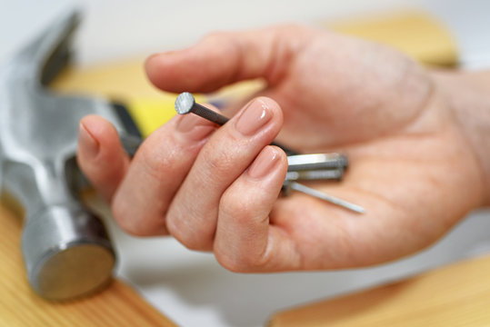 Woman hand with hammer and nails.