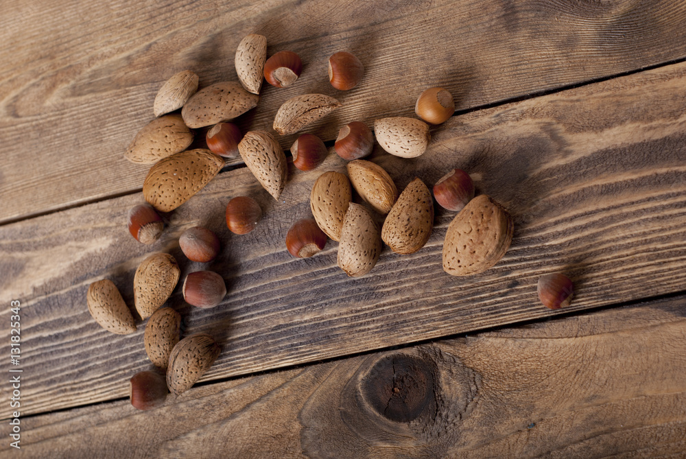 Wall mural almonds and nuts on wooden background