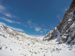 Fototapeta na wymiar White snow, blue sky and rocky peaks. Nepalese severe winter. Nepal eco travel and extreme sport.
