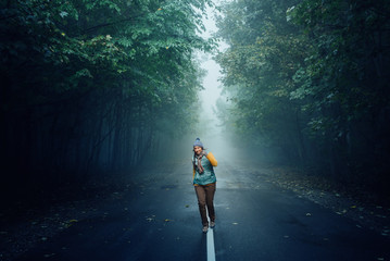 tourist girl running on a mountain road in the forest
