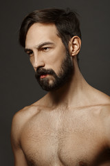 Fototapeta premium Portrait of topless serious man with beard and mustache looking