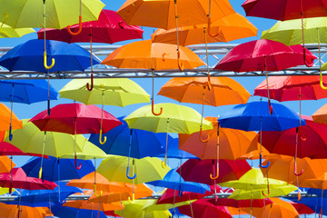 Hanging colored bright  umbrellas against blue sky - concept of freedom, flight and protection. Selective focus.