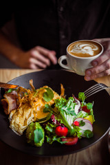 Breakfast table, man eating breakfast and drink coffee, close up