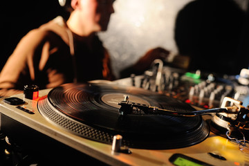 vinyl decks in close-up on a background of a DJ. club music