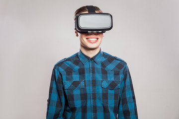 emotional funny man wearing virtual reality goggles. Studio portrait of video game designer wearing VR headset. studio shot isolated on gray background.