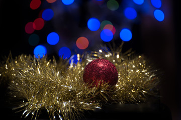 Christmas ball ornament with gold garland on bokeh background