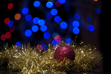 Christmas ball ornament with gold garland on bokeh background